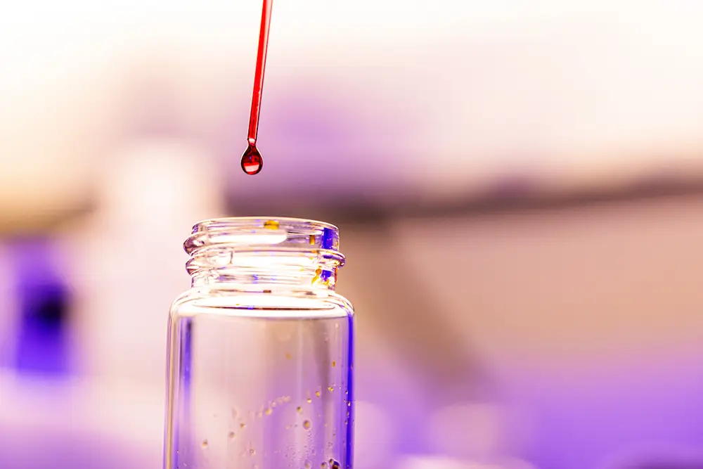 Detail photo of a solution droplet on the end of a glass dropper before going into a glass vial in the Polymer Characterization Laboratory for a research photo created on January 19, 2023. Photo by Steven Bridges/University of Tennessee.
