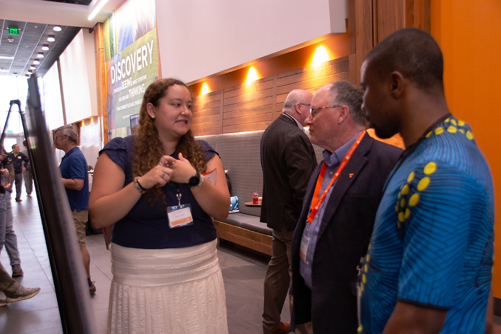 Symposium participant Natalie Bacallao presents her poster to a graduate student and one of the symposium judges.