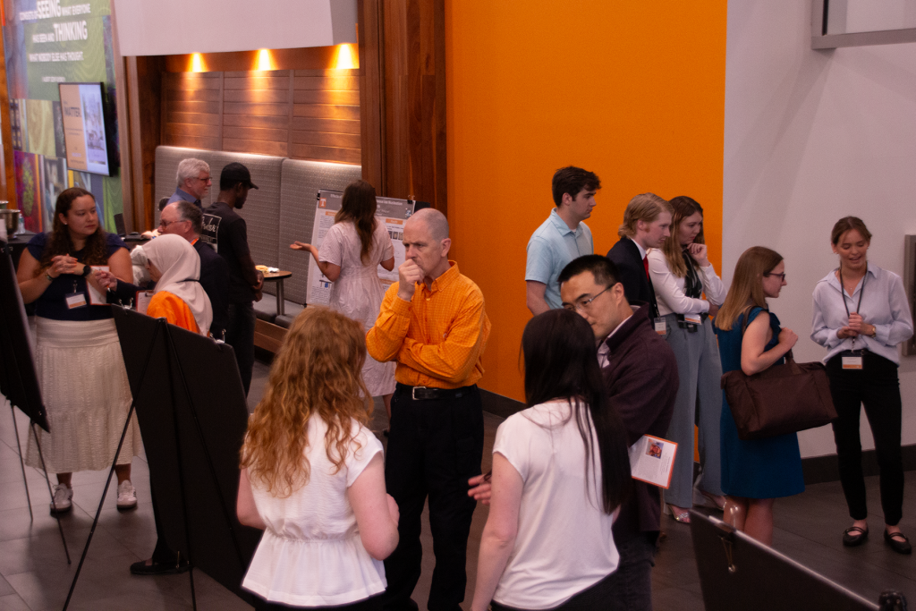 A wide shot of the symposium poster session, including students, faculty members, and guests.