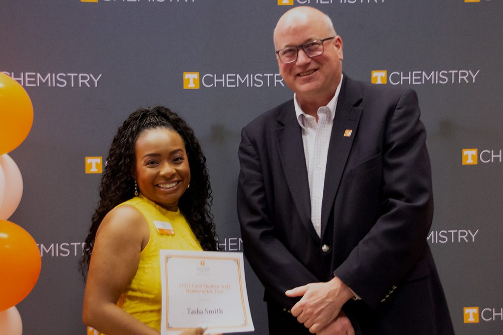 Tasha Smith stands with Dr. Shaughnessy holding the certificate for her award.